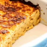 Baked macaroni and cheese with a crispy golden crust in a white casserole dish.